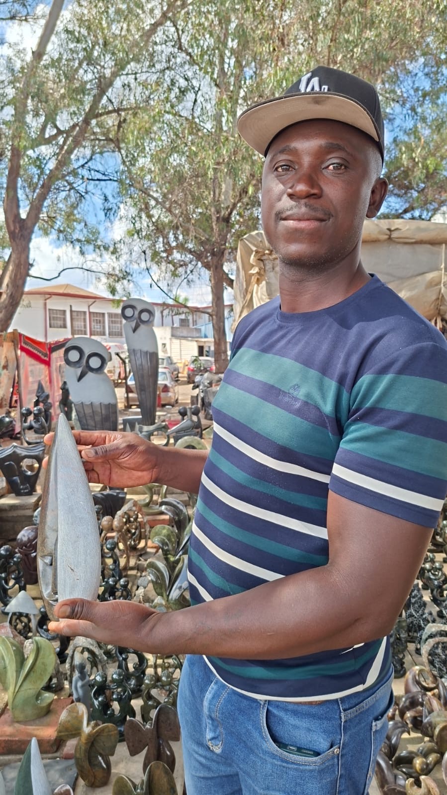 Sculptor holding a polished stone carving at the workshop